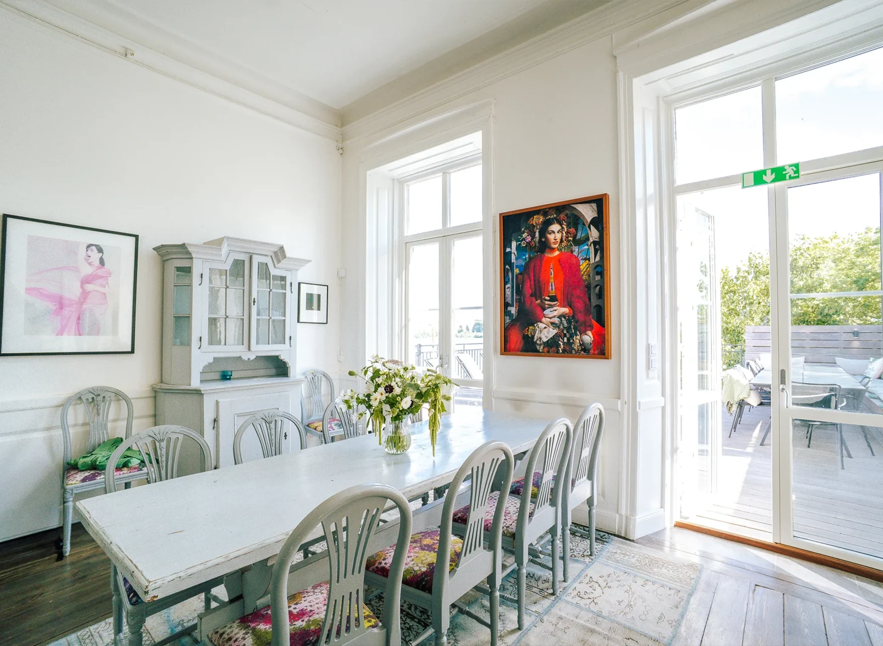 Matplats i sviten med vitt långbord och dörr ut mot terrassen